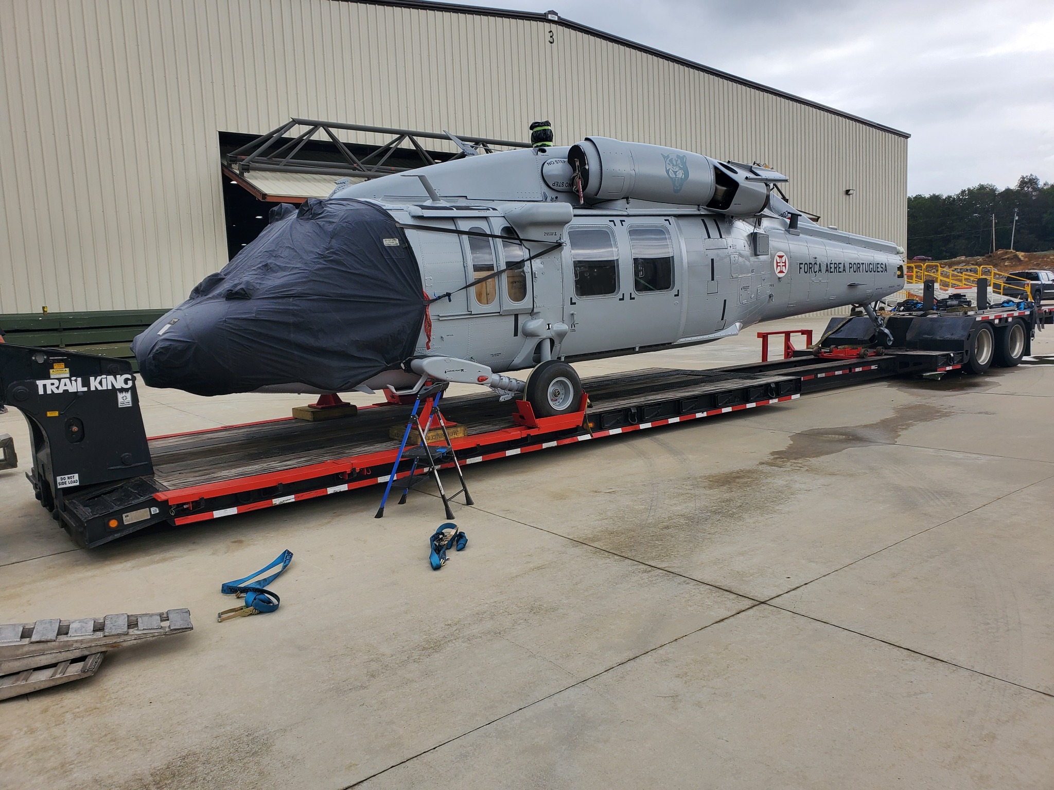 A helicopter secured to a lowboy trailer for ground transport